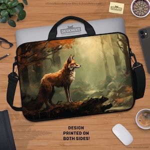 Può includere: Una custodia per laptop con un'illustrazione di una volpe in una scena di foresta con colori autunnali. La custodia ha un manico e una tracolla neri. Il testo "DESIGN PRINTED ON BOTH SIDES!" è visibile.