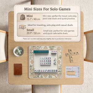 May include: A wooden table with a mahjong set, small bowl with green balls, and a brown notebook. The mahjong set is on a floral patterned mat. Text on the table reads "Mini Sizes For Solo Games".