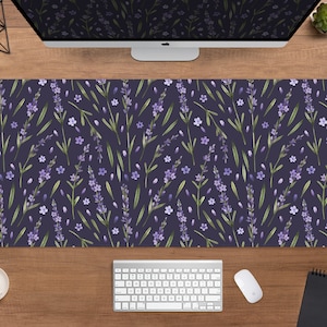Peut inclure: Un tapis de bureau rectangulaire avec un motif aquarelle de fleurs et de feuilles de lavande sur un fond violet foncé. Le motif floral comprend des brins de lavande violets et de petites fleurs blanches. Le tapis est conçu pour protéger une surface de bureau.
