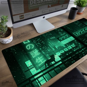 Pode incluir: Tapete de secretária verde e preto com um design de paisagem urbana, texto japonês e uma silhueta de gato. O tapete tem o texto "Desk Neko" e "Aesthetic Desk Mats and Mouse Pads".