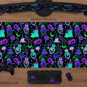 May include: A black desk mat featuring a repeating pattern of potion bottles, bird skulls, candles, mushrooms, feathers, and crescent moons in neon green, purple, and teal. The mat measures 90x40 cm. The website address deskneko.com is printed at the bottom.