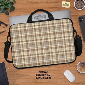 May include: Laptop sleeve with a brown and beige plaid pattern. The sleeve has a black handle and a detachable shoulder strap. The text "DESIGN PRINTED ON BOTH SIDES!" is visible. The brand name "DESKNEKO" is also visible.