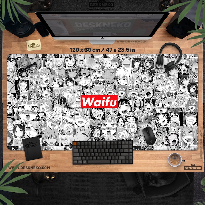 May include: A large rectangular desk mat featuring a black and white anime-style collage of faces. The word "Waifu" is in red block letters. The mat measures 47 x 23.5 inches and has the website address www.DESKNEKO.COM printed on it.