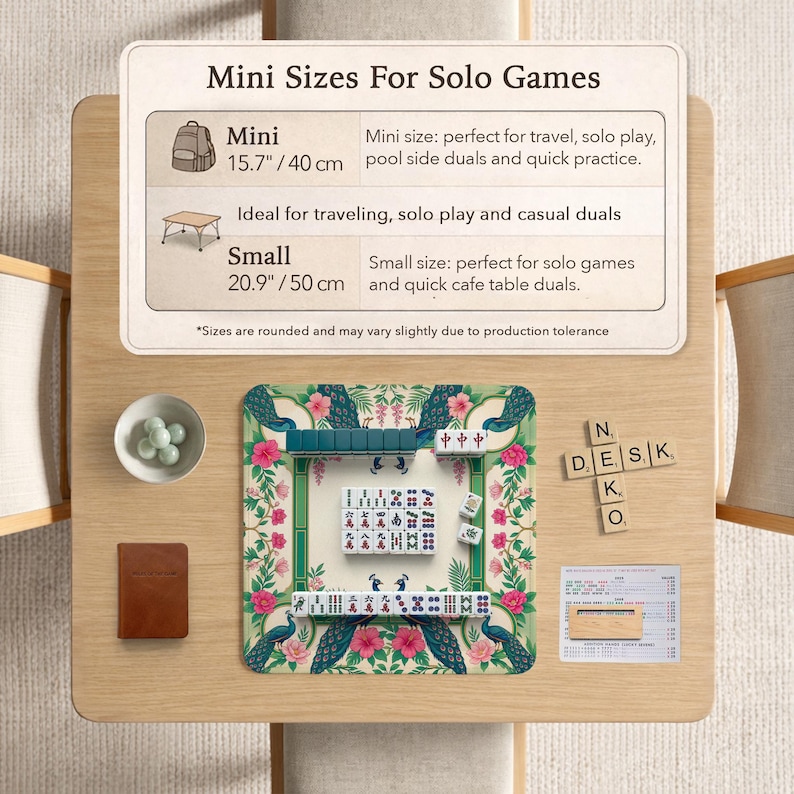 May include: A Mahjong set on a floral mat with peacock illustrations, featuring tiles with Chinese characters and symbols. A sign displays Mini Sizes For Solo Games, listing 15.7 inches and 20.9 inches, alongside a small bowl, a notebook, and wooden letter tiles.