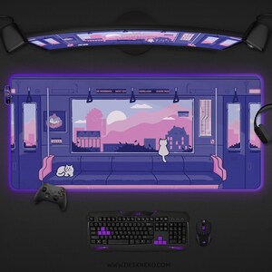 Op de afbeelding: Een grote, rechthoekige bureaumat met een paarse en blauwe anime-stijl illustratie van een treininterieur met katten. De mat heeft een gloeiende paarse rand. Een toetsenbord, muis en controller zijn zichtbaar.