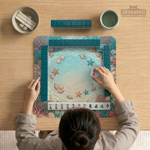 Pode incluir: Uma pessoa jogando Mahjong em uma mesa de madeira. O tabuleiro apresenta uma cena de praia com conchas e estrelas do mar. As pe&ccedil;as turquesas est&atilde;o dispostas ao redor do tabuleiro. Outras pe&ccedil;as do jogo incluem dados e uma tigela pequena.
