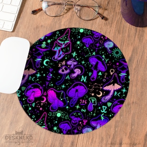 May include: Round black mousepad with a vibrant pattern of purple, pink, and teal mushrooms, stars, and celestial symbols. The mousepad has the text "DESKNEKO" and "WWW.DESKNEKO.COM" printed on it.