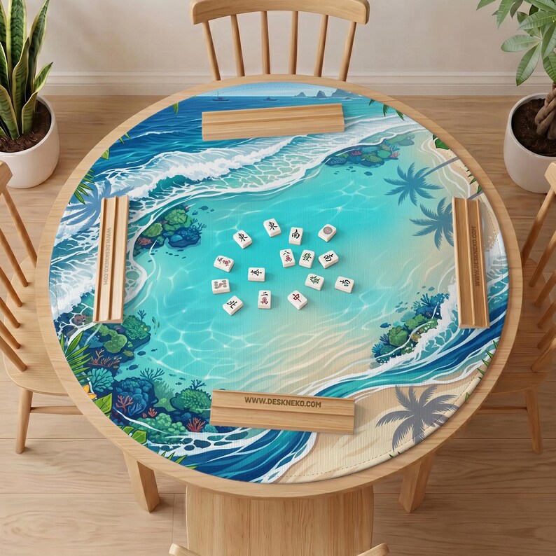 May include: A round table mat featuring a tropical beach scene with turquoise water, white waves, coral reefs, and palm trees. The mat includes four wooden tile racks with the text WWW.DESKNEKO.COM and several mahjong tiles in the center.