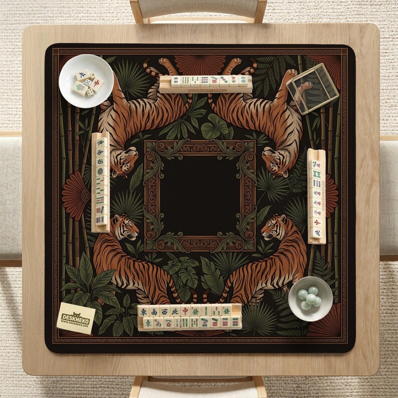 May include: A square mahjong table mat with a tiger and jungle design. The mat features four tigers, bamboo, and tropical foliage. The mat is surrounded by a wooden frame, with mahjong tiles and accessories.
