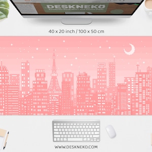 May include: A pink desk mat with a pixelated cityscape design, featuring buildings, stars, and a crescent moon. The mat measures 40 x 20 inches and has the text "DESKNEKO" and "www.deskneko.com".