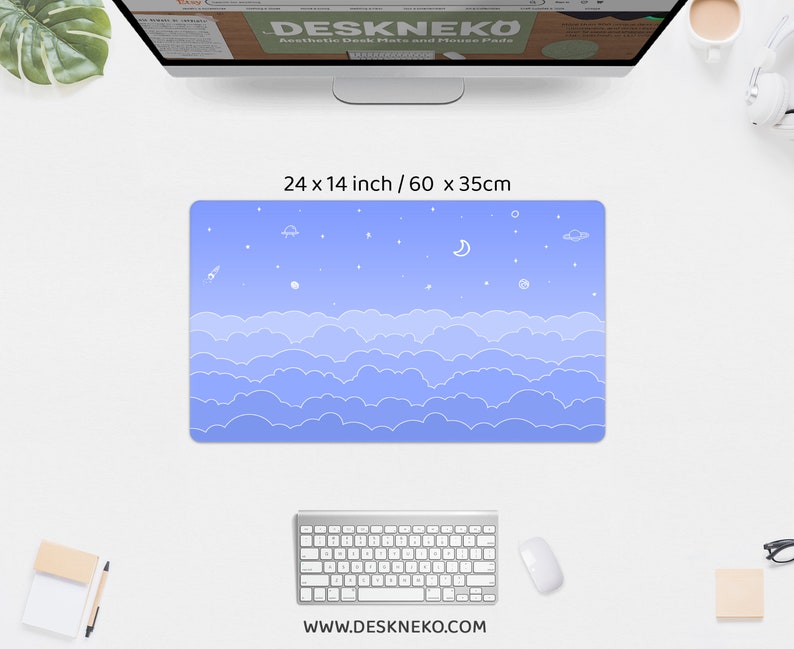 K&ouml;nnte beinhalten: Blaues Schreibtisch-Pad mit Wolken- und Weltraum-Design. Das Pad misst 60 x 35 cm und hat ein sich wiederholendes Wolkenmuster am unteren Rand und Sterne, Planeten, eine Rakete und einen Halbmond am oberen Rand. Die Website-Adresse www.deskneko.com ist unten aufgedruckt.