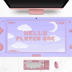 K&ouml;nnte beinhalten: Ein lila Gaming-Mauspad mit Retro-Videospiel-Design. Das Pad zeigt den Text "HELLO PLAYER ONE" und einen pixeligen Himmel mit Wolken, Sternen und einem Mond. Eine rosa Tastatur und Maus sind ebenfalls sichtbar.
