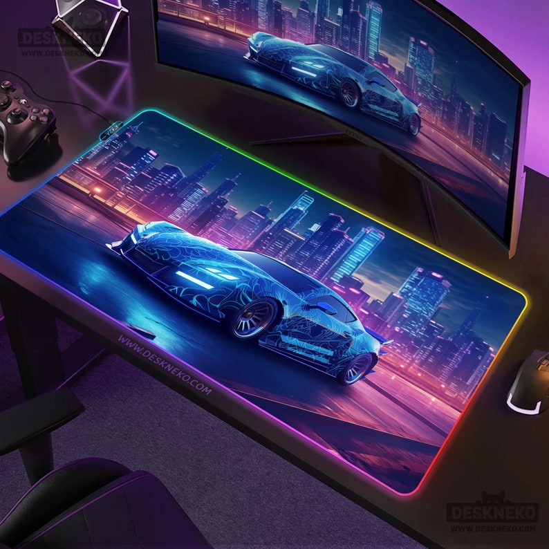 May include: A gaming mouse pad featuring a futuristic blue sports car design with neon accents, set against a cityscape backdrop. The pad has a glowing, multi-colored edge and the website address www.deskneko.com.