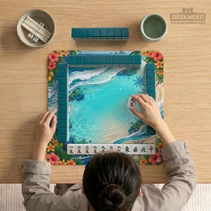 May include: A square mahjong mat featuring a tropical beach scene with turquoise water, white sand, and hibiscus flowers. The mat is surrounded by dark teal mahjong tiles, with a row of tiles at the bottom displaying red and black Chinese characters.
