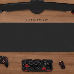 May include: A black rectangular gaming mouse pad, 31 x 12 inches (80 x 30 cm), with a textured surface. The pad is surrounded by a keyboard, mouse, controller, and headset, all in black and red.