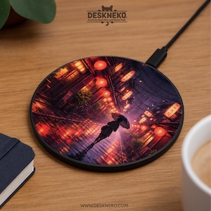 Puede incluir: Cargador inalámbrico negro redondo con una vibrante ilustración de una persona con un paraguas caminando por una calle bordeada de faroles rojos. El cargador tiene el texto "Deskneko" y "www.deskneko.com".
