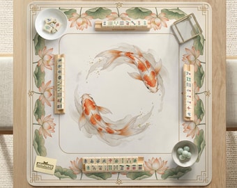 May include: A wooden mahjong table with a cream-colored mat featuring two koi fish and lotus flowers. The table includes tiles, dice, and a small bowl with green balls. The logo "DESKNEKO" is visible.