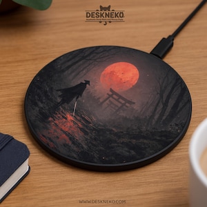 Puede incluir: Cargador inalámbrico redondo negro con una ilustración dramática de un samurái en un bosque bajo una luna roja. El cargador tiene un cable negro y el texto "DESKNEKO" y "www.deskneko.com".