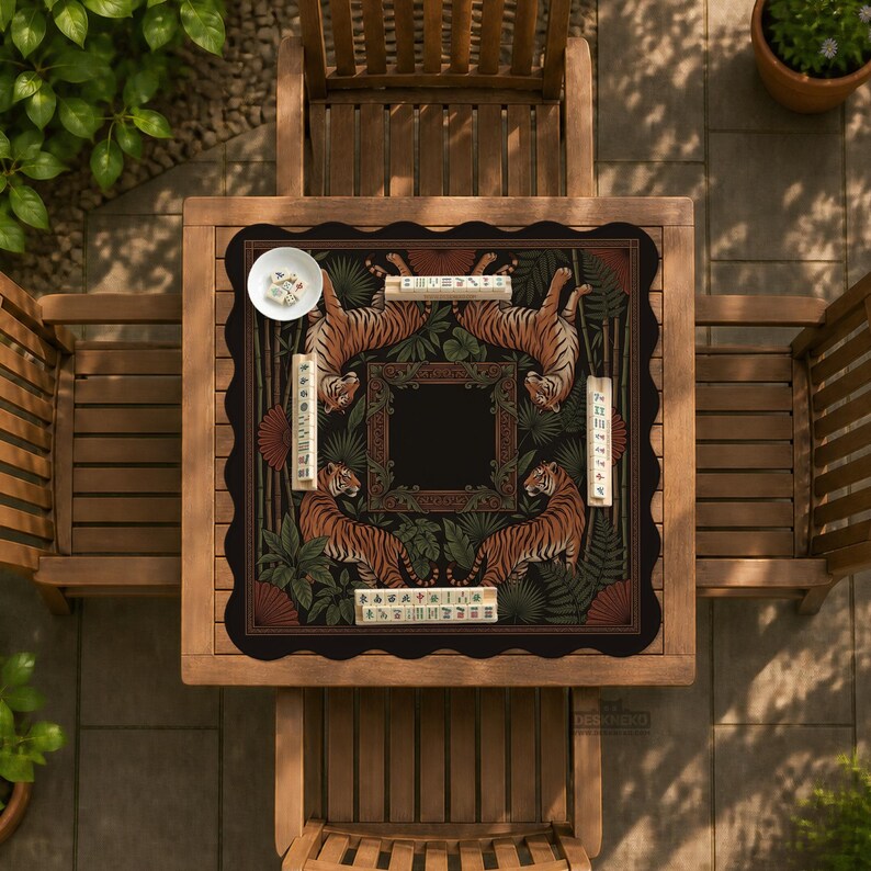 May include: A square, black and brown decorative table cover featuring a tiger design. The cover has a scalloped edge and is placed on a wooden table. The tiger design is surrounded by green foliage and text.