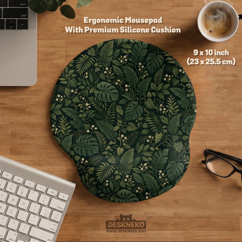 K&ouml;nnte beinhalten: Ein ergonomisches Mauspad mit Premium-Silikonkissen und einem dunkelgr&uuml;nen botanischen Muster aus tropischen Bl&auml;ttern und kleinen wei&szlig;en Bl&uuml;ten. Das Mauspad misst 23 x 25,5 cm und enth&auml;lt den Text Ergonomic Mousepad With Premium Silicone Cushion.