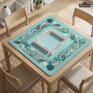 May include: A square, pale blue game mat featuring a border of seashells, starfish, and coral. A wooden frame with game pieces is in the centre. The mat is on a wooden table with chairs. The text "DESKNEKO" is in the upper right corner.