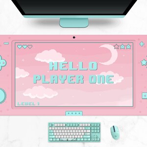 K&ouml;nnte beinhalten: Ein rosa Gaming-Mauspad mit Retro-Videospielkonsolen-Design. Das Pad zeigt den Text "HELLO PLAYER ONE" in pixeligen blauen Buchstaben, mit einem Himmel- und Wolkenhintergrund. Eine passende Tastatur und Maus sind ebenfalls sichtbar.