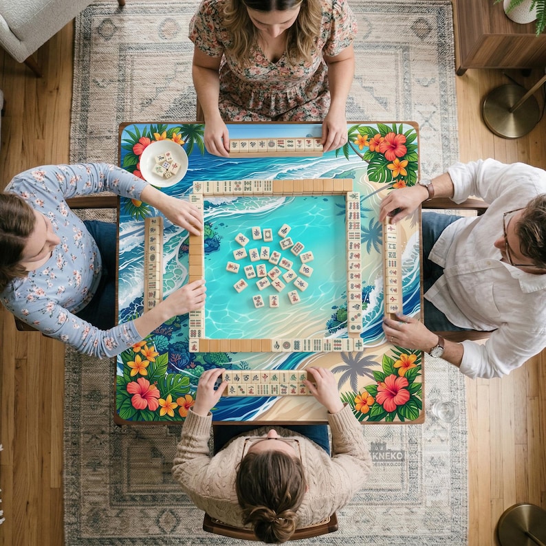 May include: A top-down view of a Mahjong game in progress. The game board features a tropical beach scene with palm trees and hibiscus flowers. Four people are seated around the table, each with a hand of tiles.