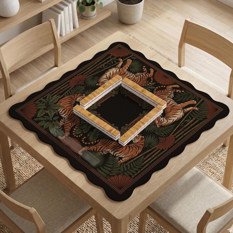 May include: A square black table mat with a scalloped edge, featuring a tiger and foliage design. The mat has a central square opening and is surrounded by a border of tigers, ferns, and bamboo. A set of wooden game pieces are placed on top.