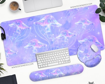 May include: A desk setup with a large rectangular mousepad, a round mousepad, and a wrist rest, all with a jellyfish design. The jellyfish are in shades of purple, pink, and blue. The website address www.deskneko.com is visible.