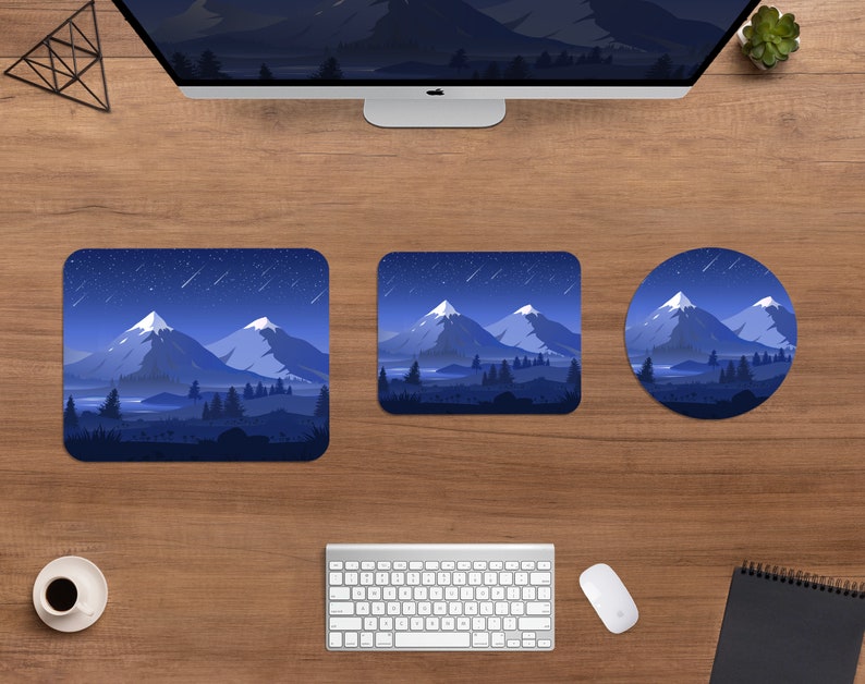 May include: A desktop setup featuring a computer monitor, keyboard, and mouse, with a square, rectangular, and round mousepad. Each mousepad displays a mountain landscape under a starry night sky, with shades of blue and white.