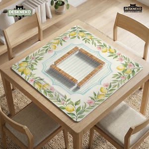May include: A square table mat with a lemon and floral design. The mat features a light blue and white striped center, surrounded by a border of lemons, pink flowers, and green leaves. The mat has a wooden frame in the center.