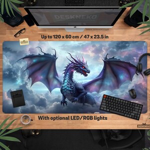 May include: A large rectangular desk mat featuring a fantasy dragon design with a purple and blue color scheme. The mat measures up to 47 x 23.5 inches and includes the text "With optional LED/RGB lights". The mat is designed for aesthetic desk setups.