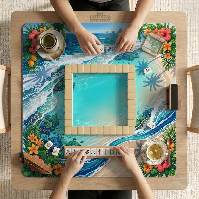 May include: A wooden Mahjong table with a tropical beach scene design. The table features a square playing area with beige tiles, surrounded by a vibrant ocean and floral border. Two people are playing Mahjong, with tiles and tea cups visible.