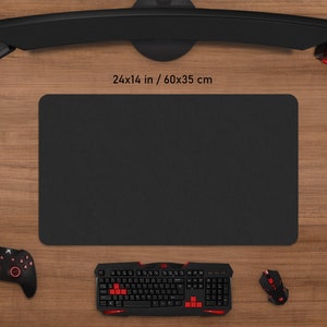 May include: A black rectangular mouse pad, 24 x 14 inches, with a textured surface, surrounded by gaming accessories. A black keyboard with red accents, a mouse, a controller, and a headset are visible.