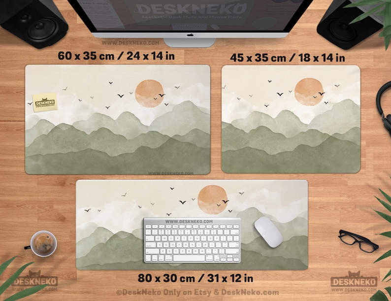 May include: Aesthetic desk mouse pads with a landscape design featuring a sun, mountains, and birds. Available in three sizes: 24 x 14 in, 18 x 14 in, and 31 x 12 in. The pads have the text "DeskNeko" and "www.DESKHEKO.COM".