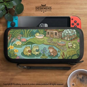May include: Black Nintendo Switch carrying case with a whimsical illustration of frogs in a pond. The case features a detailed scene with frogs reading, painting, and relaxing in bathtubs, surrounded by lily pads and a small cottage.