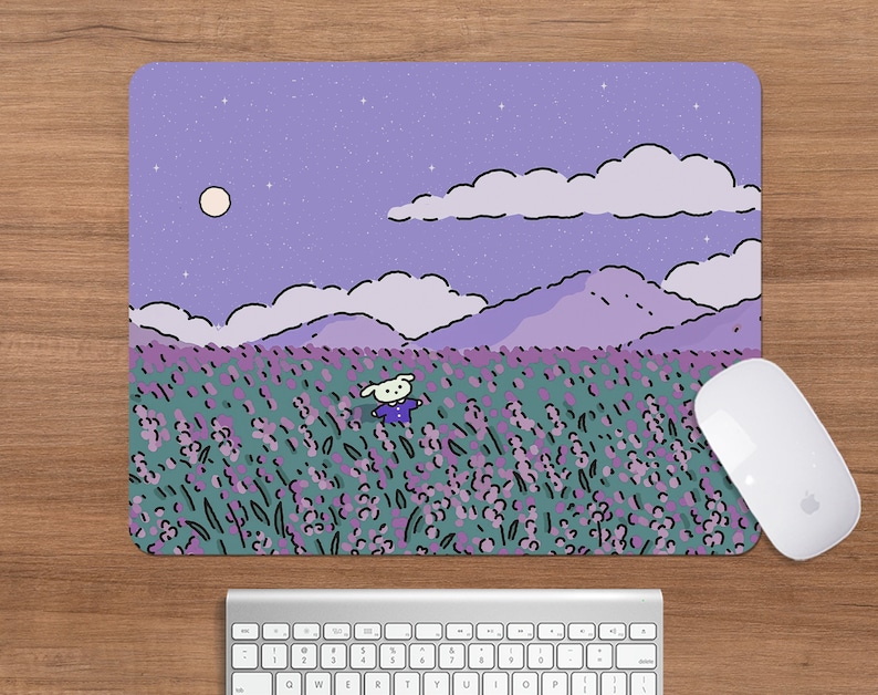 May include: A rectangular mousepad featuring a whimsical illustration of a cartoon character in a lavender field under a starry sky. The design includes mountains, clouds, and a full moon. A white mouse and keyboard are also visible.