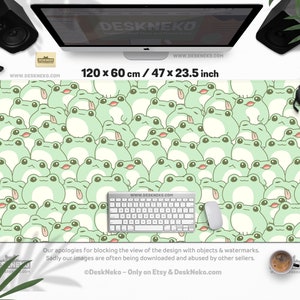 May include: A large desk mat featuring a repeating pattern of cartoon frogs in shades of green and cream. The mat measures 47 x 23.5 inches and includes a keyboard and mouse. The text "DESKNEKO" and "WWW.DESKNEKO.COM" are visible.
