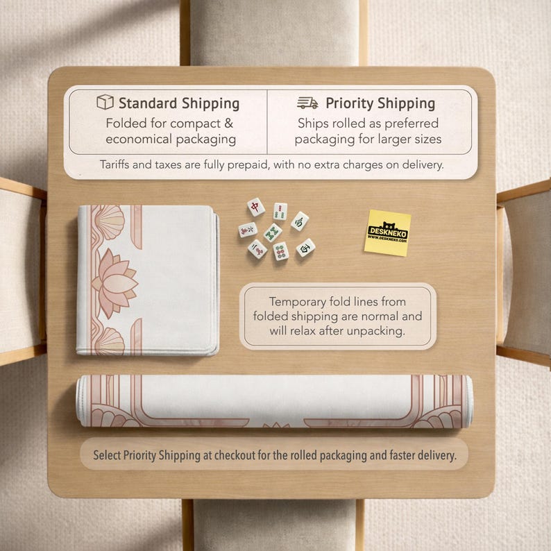 May include: A rolled-up and folded white and pink desk mat with a lotus flower design, along with a set of mahjong tiles, and a DESKNEKO sticker, are displayed on a wooden surface. The image also includes text about shipping options.