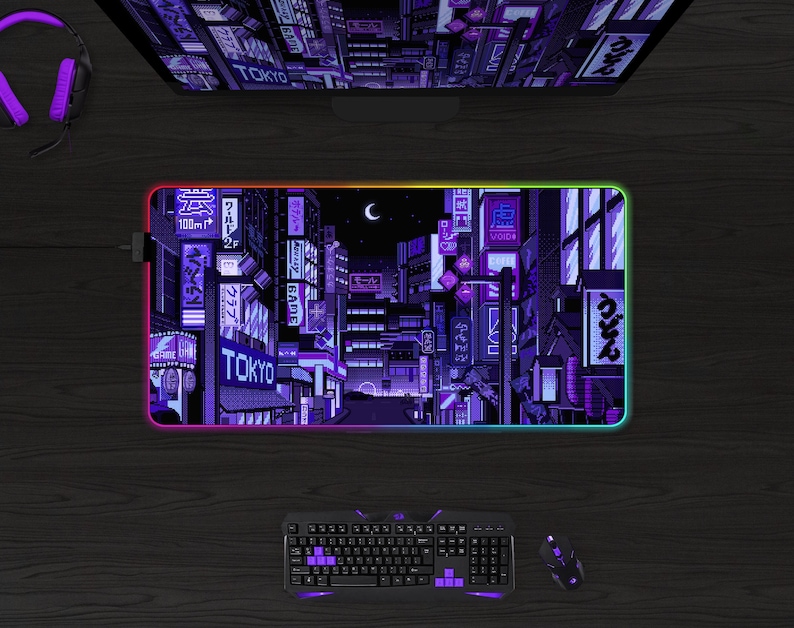 May include: A rectangular gaming mouse pad with a pixelated cityscape design in shades of purple and black, with the word "TOKYO" visible. The pad has a glowing, multi-colored edge. A keyboard, mouse, and headphones are also visible.