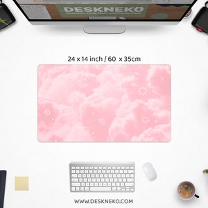 May include: A rectangular desk mat with a pink cloud design and white celestial illustrations. The mat measures 24 x 14 inches. The website address www.deskneko.com is printed at the bottom.