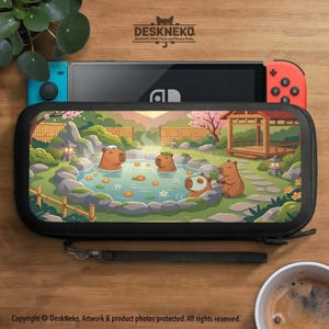 Puede incluir: Funda de transporte negra para Nintendo Switch con una colorida ilustración de carpinchos relajándose en un onsen japonés. La funda tiene una correa de muñeca y cierre de cremallera. La consola Nintendo Switch es visible dentro.