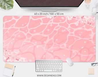 Peut inclure: Un grand tapis de bureau rose avec un motif de vagues et des fleurs de cerisier. Le tapis mesure 100 x 50 cm. Le design comprend des reflets scintillants et l'adresse du site Web www.deskneko.com.