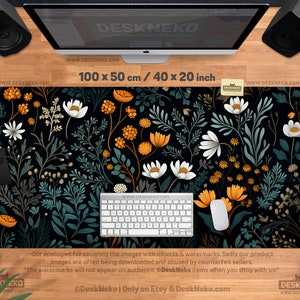 May include: A black desk mat with a floral design featuring white and orange flowers, green leaves, and stems. The mat measures 40 x 20 inches. A keyboard and mouse are on the mat.
