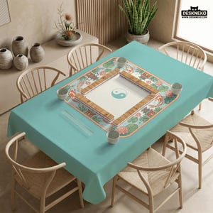 May include: A teal tablecloth with a decorative Mahjong game board featuring a Yin and Yang symbol. The board is surrounded by koi fish, lotus flowers, and traditional Asian architecture. The table is set with small bowls and chopsticks.