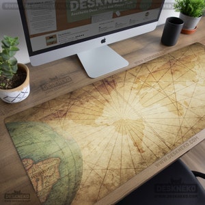 Op de afbeelding: Een rechthoekige bureaumat met een vintage wereldkaartontwerp. De mat heeft een vervaagde, verouderde uitstraling met een globe-afbeelding aan de linkerkant. De tekst "Desk Neko" en "Aesthetic Desk Mats and Mouse Pads" zijn zichtbaar.