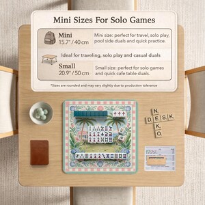 May include: A wooden table displays a mini Mahjong set with a tropical design, a small brown notebook, and a bowl of green spheres. A sign reads "Mini Sizes For Solo Games" with size details in inches and centimeters.
