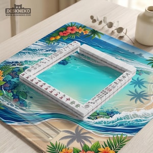 May include: A Mahjong set with white tiles and red and black characters is arranged on a tropical-themed playmat. The mat features a beach scene with turquoise water, palm trees, and floral accents. The logo "DESKNEKO" is visible in the top left corner.