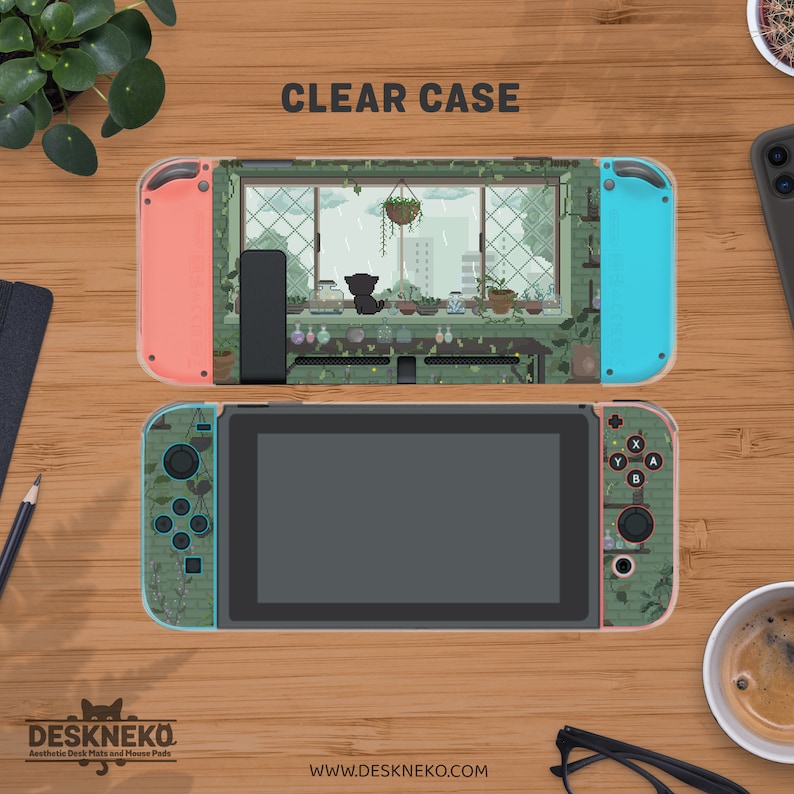 May include: A clear case for a Nintendo Switch console, with a cat and plant design. The Joy-Con controllers are coral and turquoise. The text "CLEAR CASE" is at the top. The brand name "DESKNEKO" is at the bottom. The design evokes a cozy, indoor scene.