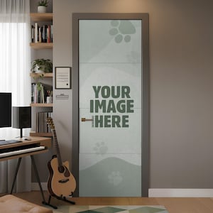 May include: A closed interior door with a light green textured surface, featuring the text "YOUR IMAGE HERE" in dark green. The door has a gray frame and a gold-colored handle. Paw prints are subtly visible on the door's surface. The door is in a room with a guitar and a desk.